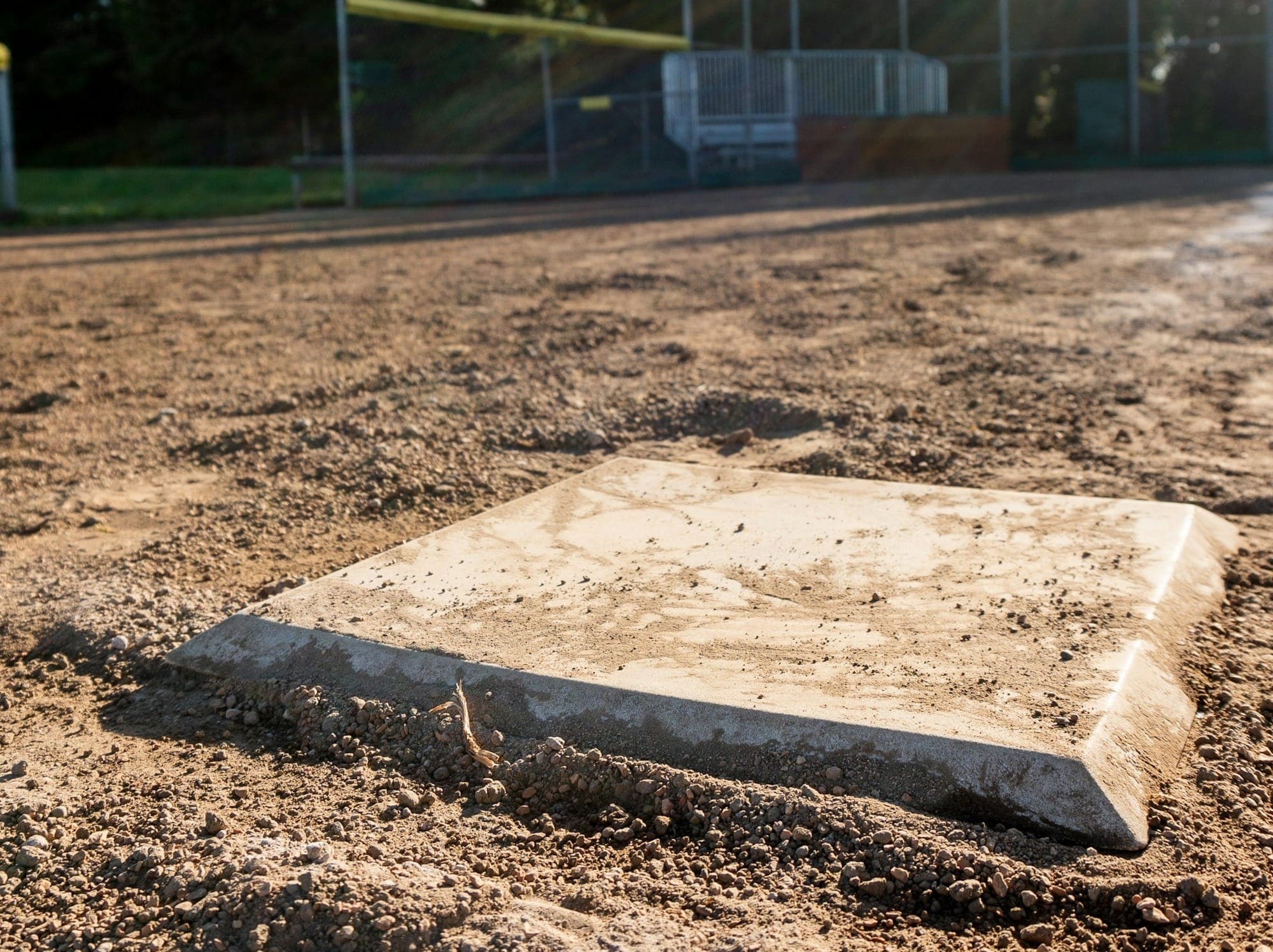 A baseball field with a base in the dirt