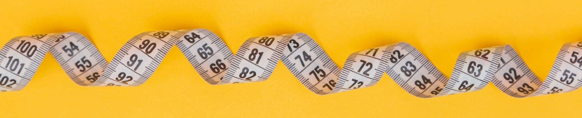 silver and black necklace on yellow textile